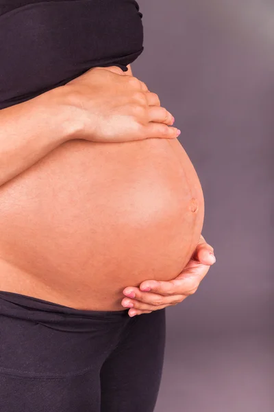 Young pregnant black woman touching her belly Stock Picture