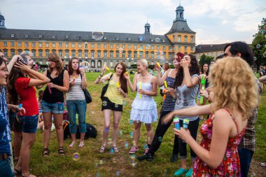 Students of University in Bonn blow bubbles clipart