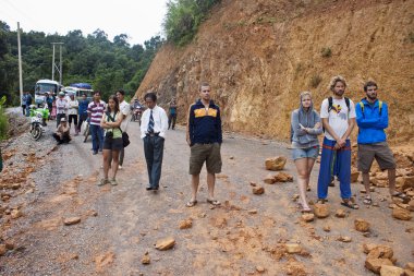 People wait for clearing a road after landslide clipart