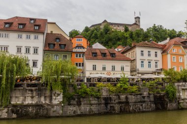 LJUBLJANA, SLOVENIA - 13 Mayıs 2019: Riverside ve Ljubljana kalesi, Slovenya