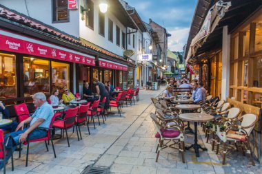 SARAJEVO, BOSNIA ve HERZEGOVINA - 11 Haziran 2019: Saraybosna Bascarsija diskinde kafeleri olan Dar Sokak. Bosna-Hersek