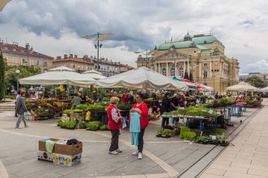 RIJEKA, CROATIA - MAY 23, 2019: Stalls of Rijeka Main Market, Croatia. Ivan Zajc Rijeka Croatian National Theatre in the background.