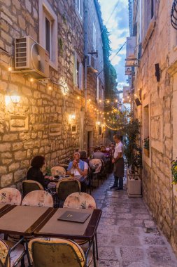 KORCULA, CROATIA - MAY 29, 2019: Alley with open air restaurant in Korcula town, Croatia