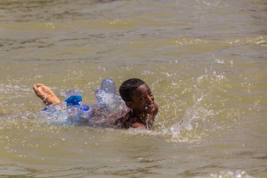 TANA, ETHIOPIA - 1 Nisan 2019: Çocuklar Tana gölünde plastik şişelerle yüzüyorlar, Etiyopya