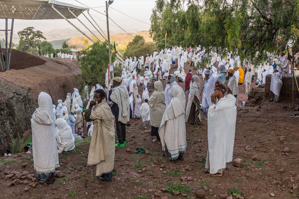 ЛАЛИБЕЛА, ЭТИОПИЯ - 31 МАРТА 2019: Группа преданных во время воскресной службы в Бет Медхане Алем, высеченной в скале церкви в Лалибела, Эфиопия