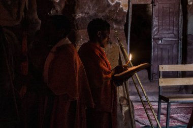 TIGRAY, ETHIOPIA - 22 Mart 2019: Etiyopya 'nın Tigray bölgesindeki Aona Abraham Debre Tsion rock kilisesinde İncil okuyan rahip