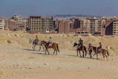 CAIRO, EGYPT - 28 HAZİRAN 2019: Giza piramitleri yakınlarında at süren insanlar, Mısır