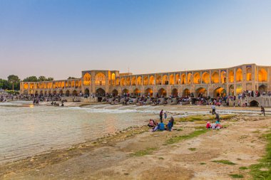 ISFAHAN, İRAN - 9 Temmuz 2019: İnsanlar İran 'ın İsfahan kentindeki Khaju köprüsünde akşamın keyfini çıkarıyorlar