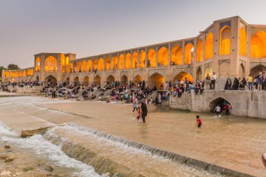 ISFAHAN, İRAN - 9 Temmuz 2019: İnsanlar İran 'ın İsfahan kentindeki Khaju köprüsünde akşamın keyfini çıkarıyorlar
