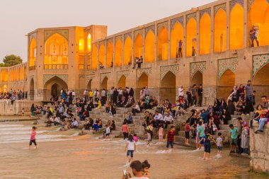 ISFAHAN, İRAN - 9 Temmuz 2019: İnsanlar İran 'ın İsfahan kentindeki Khaju köprüsünde akşamın keyfini çıkarıyorlar