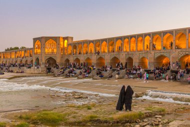 ISFAHAN, İRAN - 9 Temmuz 2019: İnsanlar İran 'ın İsfahan kentindeki Khaju köprüsünde akşamın keyfini çıkarıyorlar