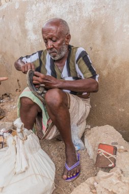 TADJOURA, DJIBOUTI - APRIL 20, 2019: Shoe repairman at a market in Tadjoura, Djibouti