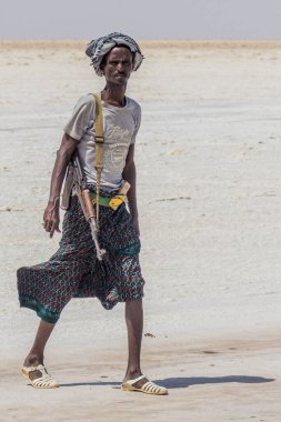 DANAKIL, ETHIOPIA - MARCH 24, 2019: Armed Afar guard at a salt flat in the Danakil depression, Ethiopia.