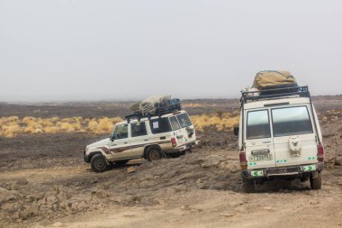 AFAR, ETHIOPIA - MARCH 26, 2019: Vehicles crossing lava fields on their way from Erta Ale volcano in Afar depression, Ethiopia