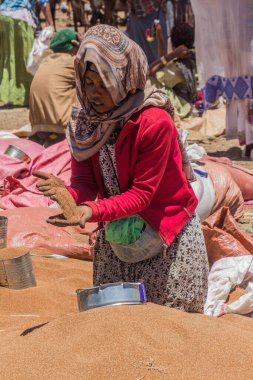 LALIBELA, ETHIOPIA - MARCH 30, 2019: Grains seller at the Saturday market in Lalibela, Ethiopia