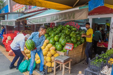 KARS, TURKEY - 18 Temmuz 2019: Kars, Türkiye 'deki bir meyve ve sebze dükkanında karpuz atan ve yakalayan işçiler