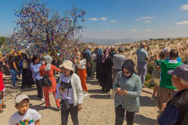 GOREME, TURKEY - 20 HAZİRAN 2019: Türkiye 'nin Kapadokya kentindeki Goreme kasabası yakınlarındaki uğursuz bir göz muskası ağacında turistler