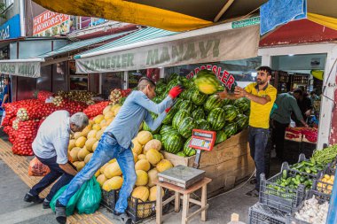 KARS, TURKEY - 18 Temmuz 2019: Kars, Türkiye 'deki bir meyve ve sebze dükkanında karpuz atan ve yakalayan işçiler