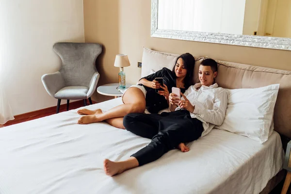 Lesbisch Paar Met Behulp Van Mobiele Telefoons Terwijl Liggend Bed — Stockfoto