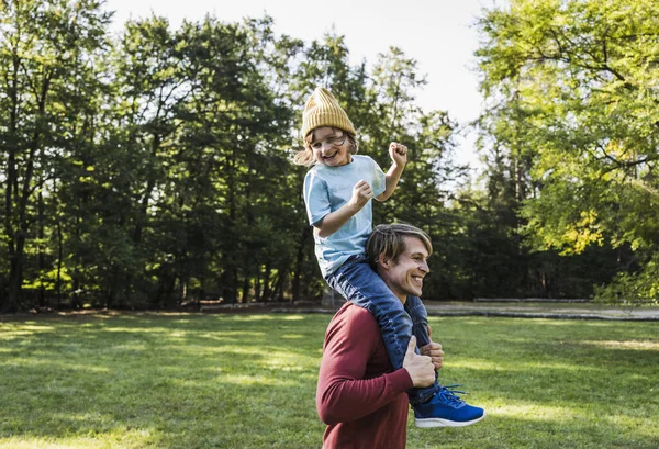 遊び心のある男運ぶ男の子上の肩に公園 — ストック写真