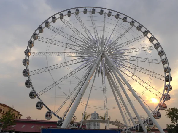 Roda gigante contra o céu escurecendo como o sol — Fotografia de Stock