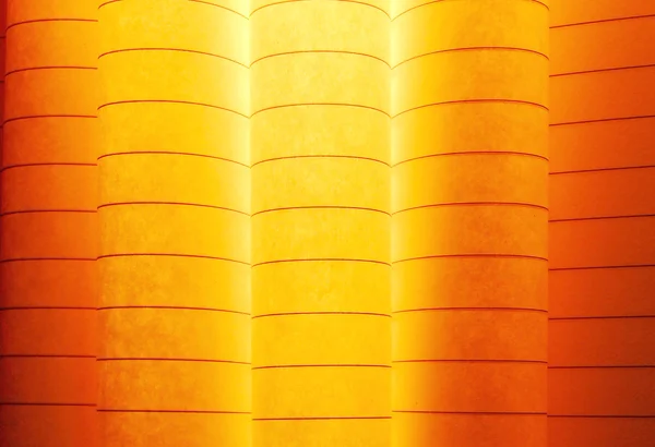 Imagem macro de folhas curvas coloridas de papel em forma de ventilador, sobre fundo laranja — Fotografia de Stock