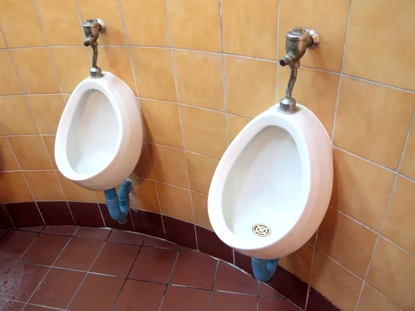 Белые фарфоровые писсуары в общественных туалетах — стоковое фото