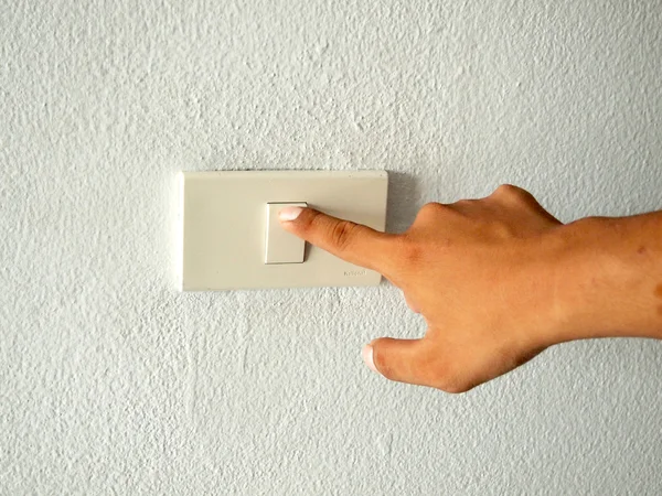 Mão com o dedo no interruptor de luz — Fotografia de Stock
