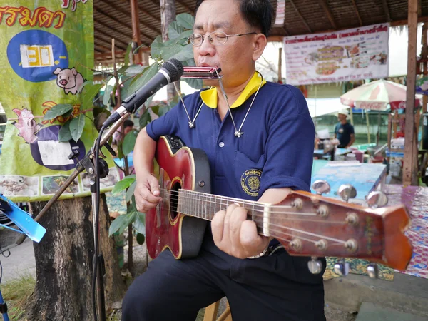 Samutprakran, Tayland - 11 Şubat: tanımlanamayan sokak müzisyeni samutprakran, 11 Şubat 2012 tarihinde Tayland'ın sokak pazarında yürüme mesafesinde gitar çalıyor — Stok fotoğraf