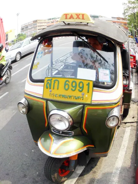 BANGKOK - 4 GENNAIO: Tuk-tuk moto taxi per strada nella zona di Wat suthat il 4 gennaio 2012 a Bangkok. La famosa moto-taxi di Bangkok chiamata tuk-tuk è un punto di riferimento della città e dei trasporti popolari. — Foto Stock