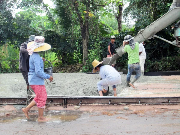 BANGKOK, THAILAND - NOVEMBRO 17, 2012: Trabalhador da construção de estradas em nova estrada de concreto no centro de Banguecoque, Tailândia . — Fotografia de Stock
