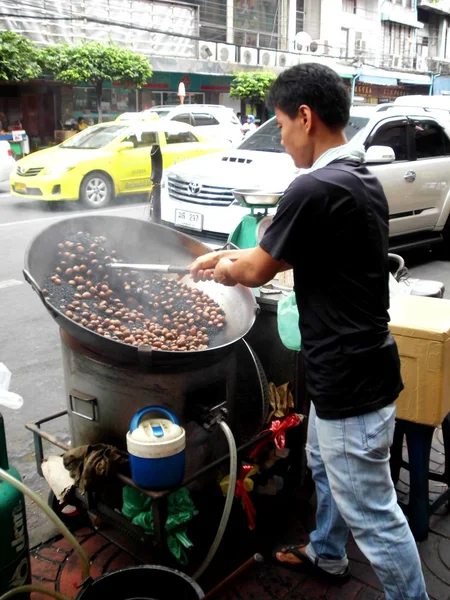 BANGKOK - 07 GENNAIO: Un uomo non identificato vende castagne il 07 gennaio 2012 a Chinatown a Bangkok. Castagne arrosto sono una merce costosa a Bangkok . — Foto Stock