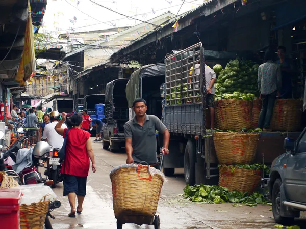 BANGKOK, THAILANDIA-SETTEMBRE 8: Un lavoratore non identificato spinge un carrello pieno di verdure attraverso il mercato vegetale l '8 settembre 2012 a Bangkok, Thailandia . — Foto Stock