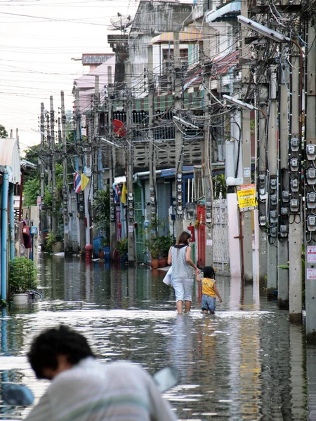 BANGKOK, THAÏLANDE - 30 OCTOBRE : Les femmes et les enfants entrent dans la maison pendant les inondations le 30 octobre 2011 Bangkok, Thaïlande — Photo