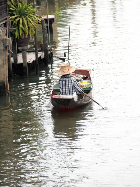 RATCHABURI, THAILAND-SEPTEMBER 2013: Local peoples sell fruits, food and products at Damnoen Saduak floating market, on September 7 2013 in Ratchaburi, Thailand. Dumnoen Saduak is a very popular tourist — стоковое фото