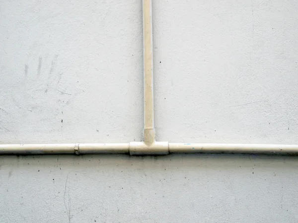 Водопроводная труба против штукатурки стены, промышленного гранж фоне — стоковое фото