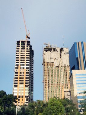 İnşaat halindeki birçok yüksek bina ve mavi gökyüzünün altındaki vinçler için iç mekan. 