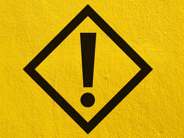 A black warning attention sign points painted on a stucco wall outside — Stock Photo, Image