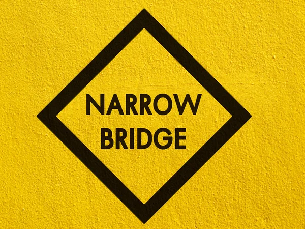 Narrow bridge Sign painted on a stucco wall outside — Stock Photo, Image