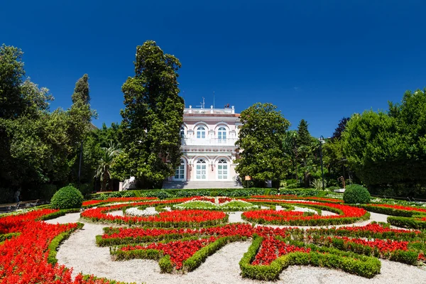 Villa angiolina met een mooie flowerbed vóór een ingang, o — Stockfoto