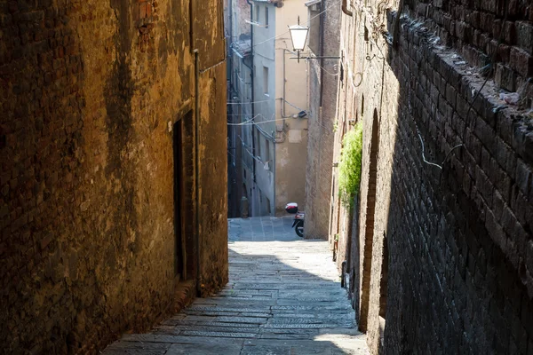 Callejón estrecho con edificios antiguos en la ciudad medieval de Siena, Tusca —  Fotos de Stock