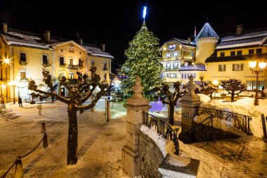 megeve Noel arifesinde, Fransız al, ışıklı merkezi kare