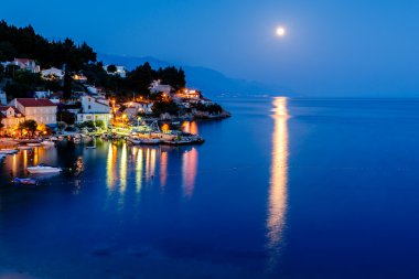 huzurlu Hırvat Köyü ve Adriyatik bay moon tarafından aydınlatılmış,