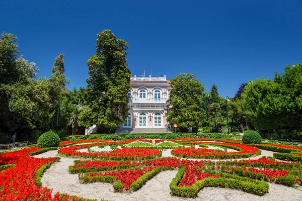 Villa angiolina mit einem schönen Blumenbeet vor dem Eingang, o — Stockfoto