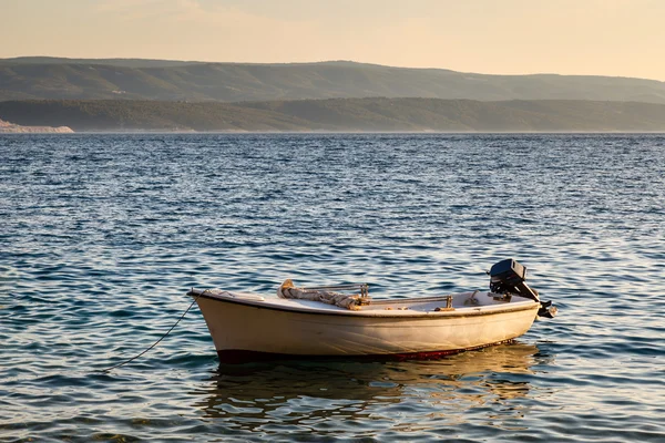 Einsames Boot und Insel Brac bei Sonnenuntergang, Dalmatien, Kroatien — Stockfoto