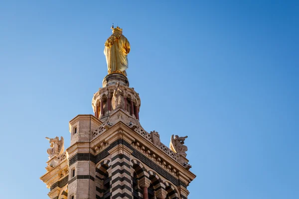 Gouden standbeeld van de madonna de kleine Jezus te houden op de top — Stockfoto