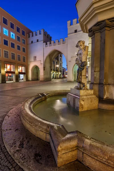 Brunnenbuberl Fountain e Karlstor Gate na noite, Munique , — Fotografia de Stock