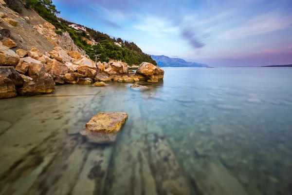 Spiaggia rocciosa e mare Adriatico trasparente vicino Omis in Evenin — Foto Stock