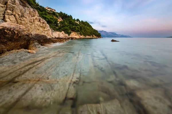 Playa rocosa y mar Adriático transparente cerca de Omis en la noche — Foto de Stock