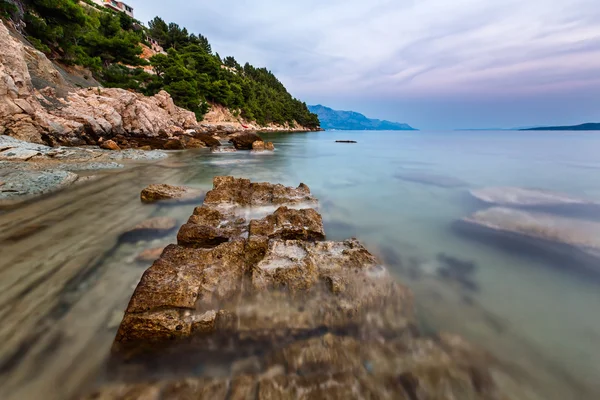 Spiaggia rocciosa e mare Adriatico trasparente vicino Omis in Evenin — Foto Stock